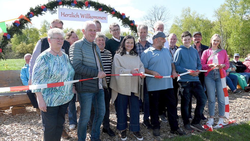 Mit dem Durchschneiden des Bandes wurde die wohl längste durchgehende Sitzbank Deutschlands am Sonnabend in Jheringsfehn eingeweiht. Foto: Melchert Stromann