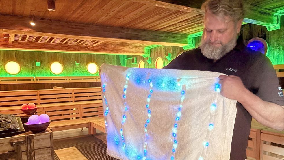 Kay Renz, Saunaleiter und Initiator des Weltrekordversuchs, mit seinem selbst kreierten LED-Handtuch. Foto: Imke Oltmanns