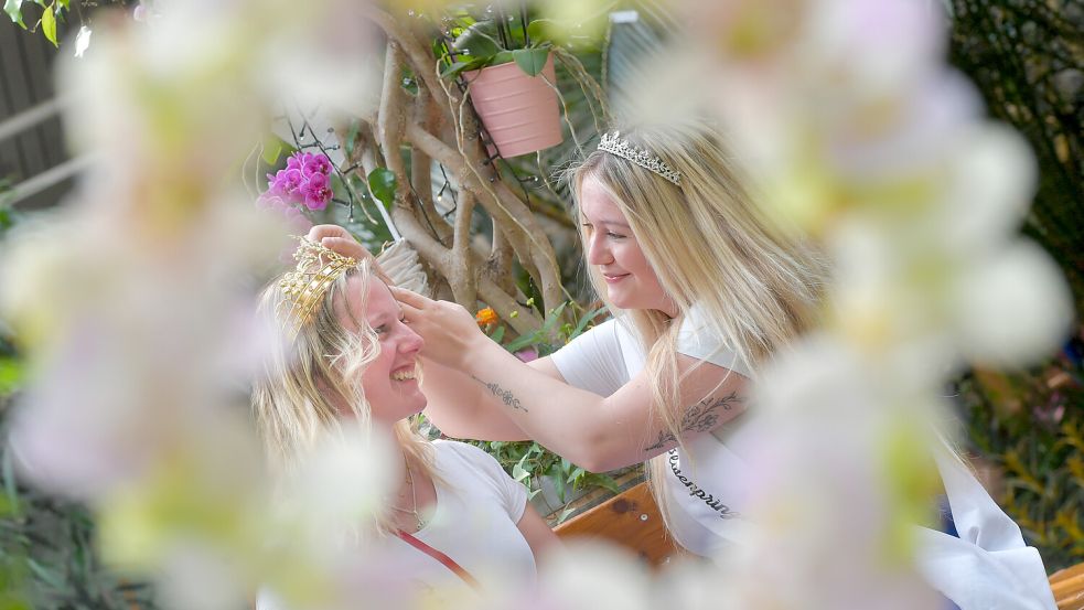 Blütenkönigin Meike Deharde (links) und Antje Kopietz bereiten sich auf den Termin in der Wiesmoorer Blumenhalle vor. Foto: Klaus Ortgies