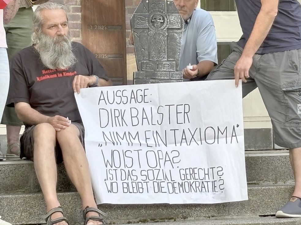 Der Satz „Nimm ein Taxi, Oma“ bezieht sich auf eine Äußerung von Dirk Balster, Geschäftsführer der Trägergesellschaft Kliniken Aurich-Emden-Norden, bei einem Workshop mit Kritikern.