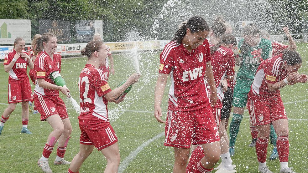Erst floss bei 33 Grad der Schweiß und dann der Sekt. Die Auricher Frauen feierten ihren Aufstieg zünftig. Foto: Vortanz