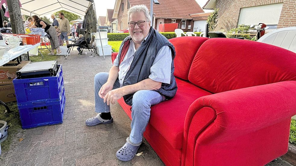 Flohmarkt-Organisator im Ruhestand: Ewald Hagedorn hat vom neuen Orga-Team das versprochene rote Sofa erhalten. So entspannt macht Verkaufen noch mehr Spaß. Foto: Nicole Böning
