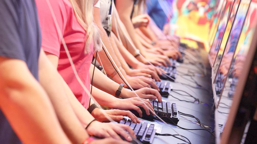 Messebesucher testen ein Computerspiel auf der Kölner Videospielmesse Gamescom.Foto: Oliver Berg/dpa Foto: Oliver Berg