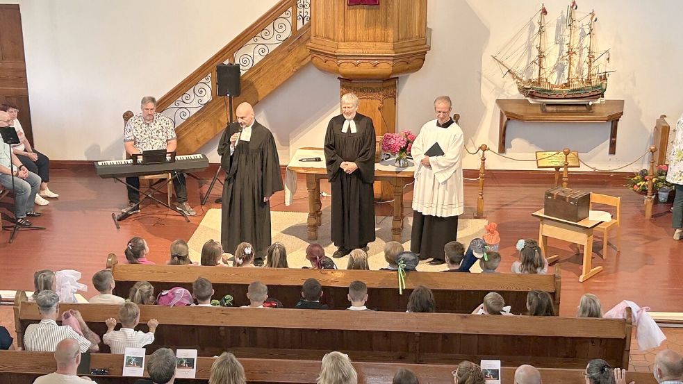Präses Frank Wessels (von links), Pastor Jörg Schulze und Bildungsreferent Andreas Langkau begrüßten die neuen Grundschüler in den ersten beiden Reihen. Foto: Beve Loose