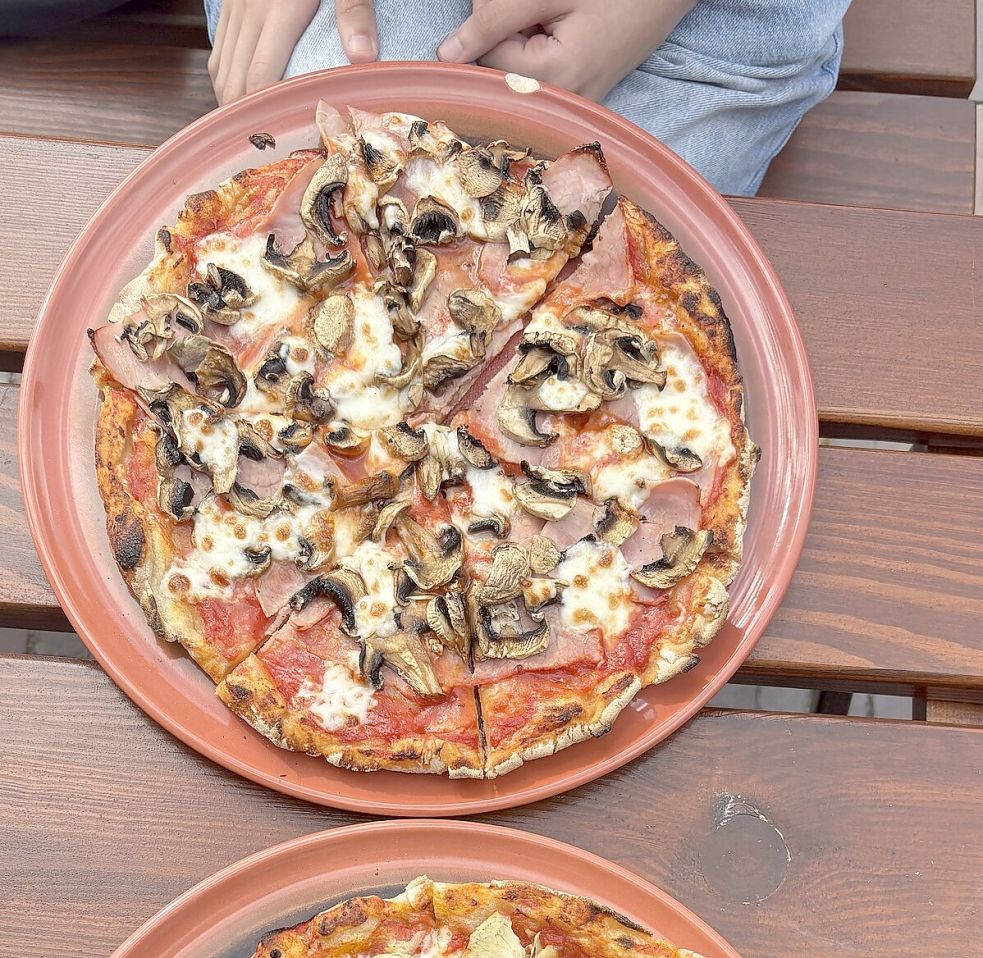 Die Pizza „Regina“ mit Mozzarella, Schinken und Pilzen (links) und die Artischocken-Pizza mit Oliven und Mozzarella. Foto: Leona Spindler