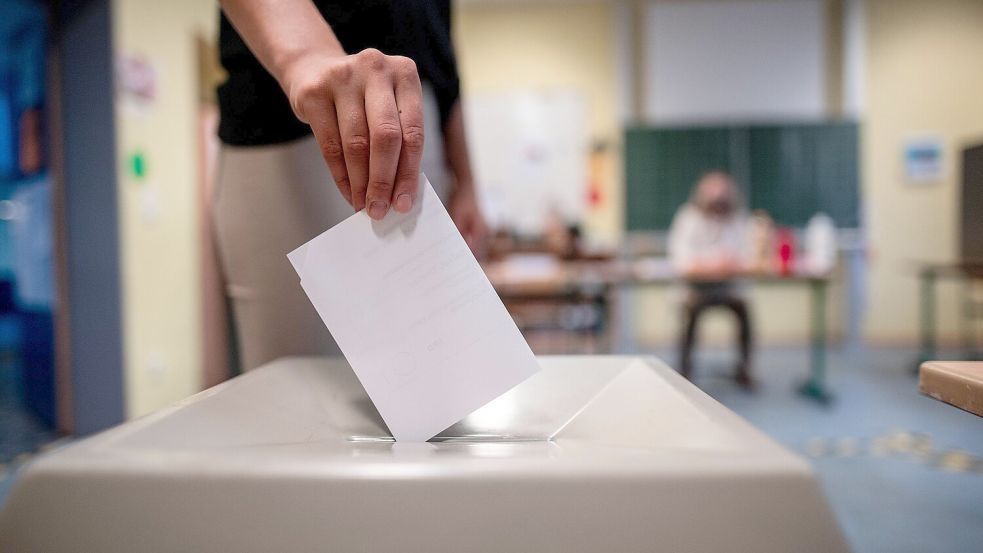 Eine Frau wirft während der Kommunalwahl 2025 in Nordrhein-Westfalen einen Wahlzettel in eine Wahlurne. Foto: dpa/Fabian Strauch