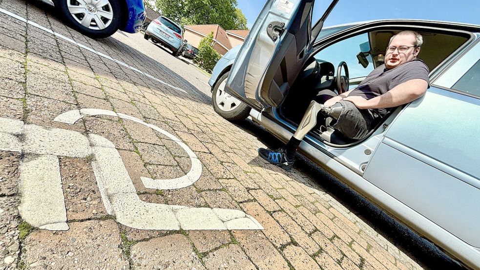 Um aus seinem Auto auszusteigen, muss Patrick Höcker die Tür ganz aufmachen und zunächst das Bein mit der Prothese aufsetzen. Erst dann kann er das rechte Bein nachziehen und sich aufrichten. Foto: Klaus Ortgies