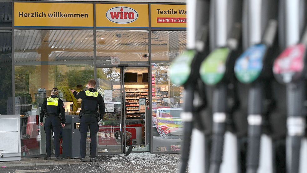 Einsatzkräfte der Polizei stehen nach der Sprengung eines Geldautomaten vor einer Tankstelle in der Papenburger Innenstadt. Die Täter seien laut Polizei in den unbesetzten Kassenraum eingedrungen und hätten den sich darin befindenden Geldautomaten gesprengt. Beim Versuch zu flüchten und auf die Bundesstraße B70 aufzufahren, kam das Fahrzeug von der Straße ab. Foto: Lars Penning/dpa