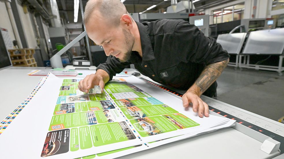 Chris Dingethal kontrolliert in der Druckerei Rautenberg einen Druckbogen. Foto: Klaus Ortgies