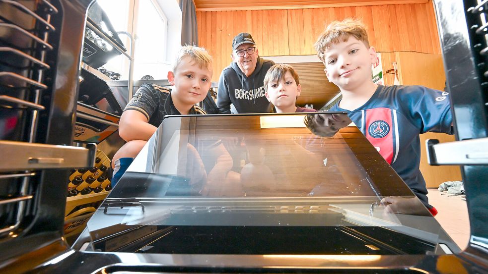 Ein Blick in den neuen Ofen: Jürgen Fraas und die drei Jungs Jonas, Oleksi und David. Foto: Klaus Ortgies