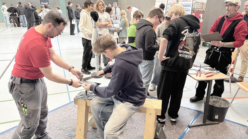 Dachdeckermeister Pascal Nink (links) zeigt Schüler Ron Zühlke, wie sich Schiefer bearbeiten lässt. Foto: Florian Ferber