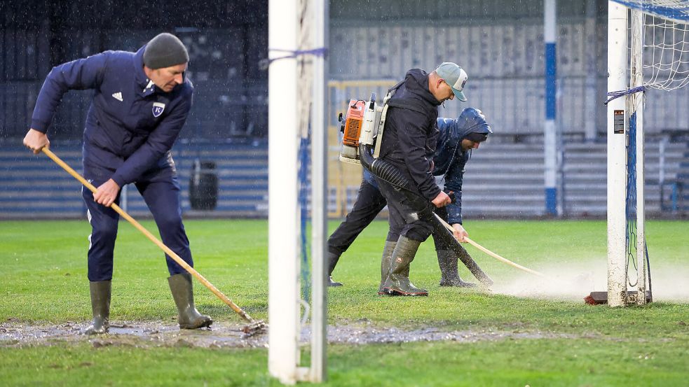 Mit Laubbläsern beseitigten emsige Helfer vor dem Spiel einzelne Pfützen.