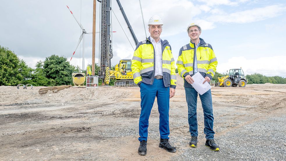 Der EWE-Vorstandsvorsitzender Stefan Dohler (links) steht im Sommer 2025 mit Projekt-Mitarbeiter Andreas Hallerstede auf dem Baugrund für die Wasserstoff-Produktionsanlage in Emden. Foto: Sina Schuldt/dpa