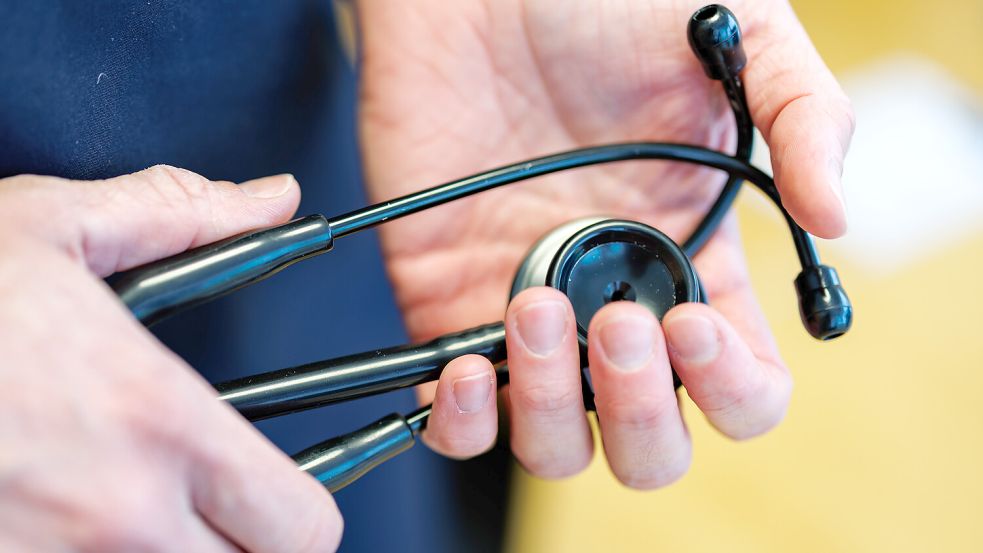 Ein Hausarzt hält in seiner Praxis sein Stethoskop in den Händen. Symbolfoto: Daniel Karmann/dpa