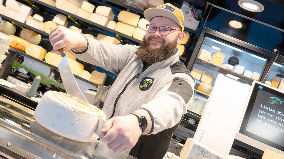 Wie viel Käse darf‘s sein? André Neubauer ist beim Stand von Käse-Frans guter Laune. Das Winterwetter sorgt für Entschleunigung, sagt er. Foto: Klaus Ortgies