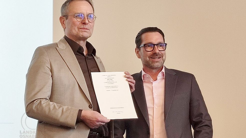 Klaus Damer (rechts), Schulfachlicher Dezernent, überreicht Martin Henke (links) seine offizielle Ruhestandsurkunde. Foto: Lukas Reynert