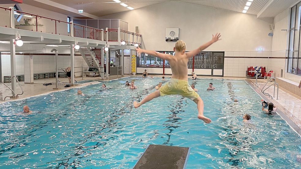 Ein Junge stürzt sich vom Sprungbrett ins Wasser. Foto: STV Hollsand