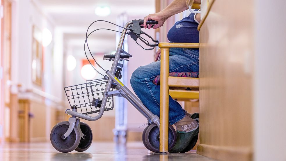 Ein alter Mann sitzt mit seinem Rollator auf einem Flur in einem Pflegeheim. Ostfriesland hat bereits jetzt eine vergleichsweise alte Bevölkerung. Das wird sich bis 2045 noch verstärken. Foto: Jens Büttner/dpa