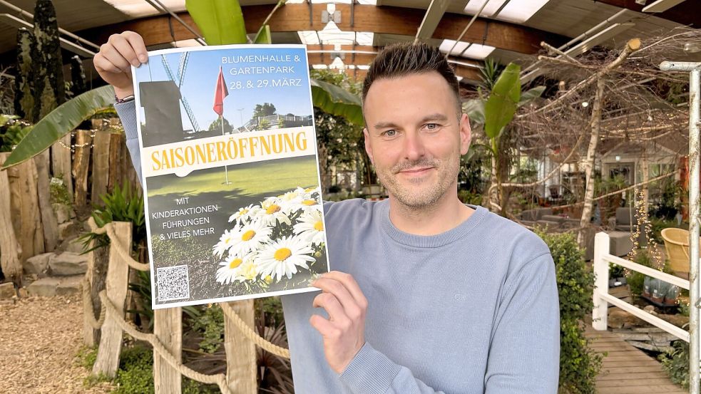 Joel Siemer von der Blumenhalle in Wiesmoor mit dem Plakat zur Saisoneröffnung der Blumenhalle am 28. und 29. März 2026. Foto: Nicole Böning