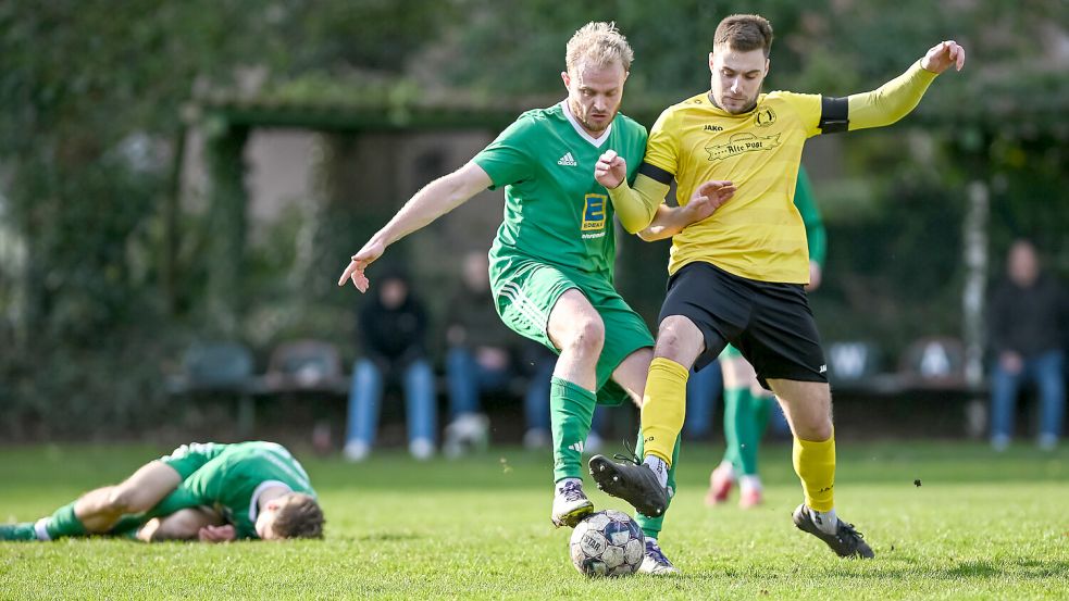 Der SV Wallinghausen (grünes Trikot Bent Bogena) und der TuS Middels (gelbes Trikot Glen Sokoli) lieferten sich ein enges Aurich-Derby, das der SVW mit 1:0 gewann. Foto: Stephan Friedrichs