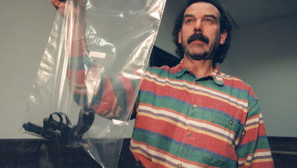 Ein Beamter der Kriminalpolizei zeigte die Tatwaffe in die Kameras der Pressefotografen. Foto: Ortgies/Archiv