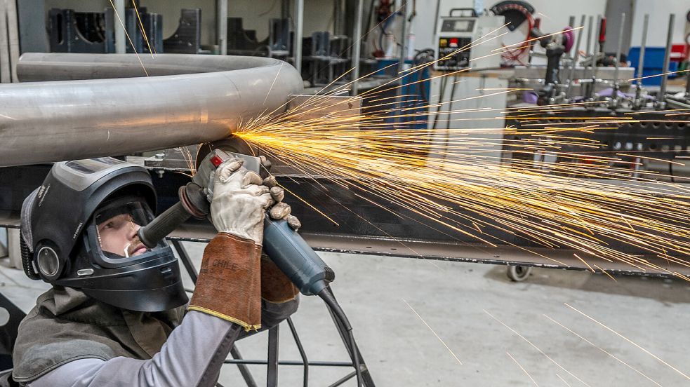 Während Tobias Müller einen Rohrbogen mit der Flex in die passende Form bringt, sprühen die Funken. Foto: Klaus Ortgies
