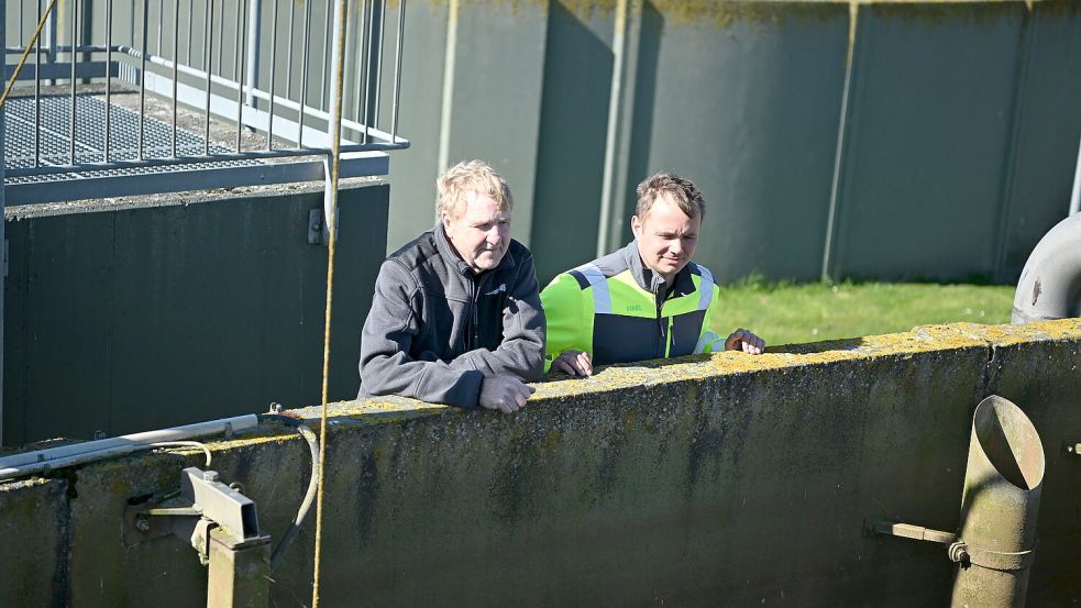 Albrecht de Vries und Daniel Schwidder vom Zentralklärwerk Pilsum/Manslagt schauen in ein mehrere Meter tiefes Speicherbecken. Fotos: Heinz Wagenaar