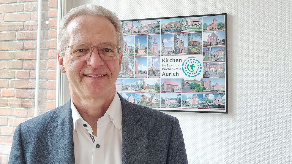 Der Auricher Superintendent Tido Janssen vor einem Plakat mit den Kirchen in seinem Kirchenkreis. Foto: Karin Böhmer