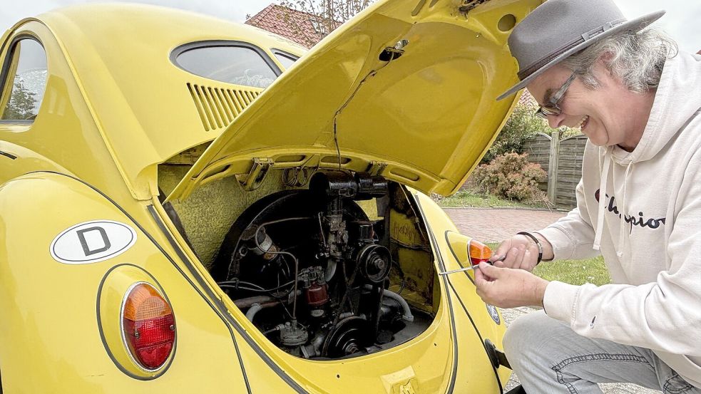 Nur dank guter Pflege ist dieser Volkswagen Typ 1 so alt geworden. Was sein Vater Gerd-Anton 1951 begann, setzt Robert Willms mit der Unterstützung seiner vier Brüder fort. Hier prüft er den Ölstand. Eine Besonderheit beim Käfer ist, dass sich der Motor hinten befindet. Foto: Susanne Ullrich