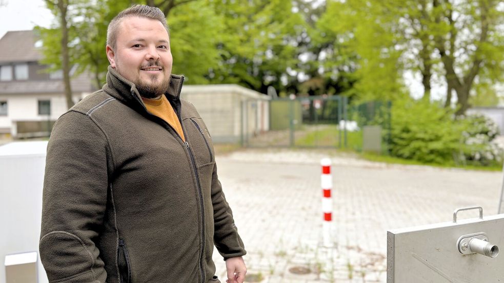 Betriebsleiter Derrick Saathoff an der neuen Pumpstation in Marcardsmoor. Im Hintergrund ist die alte EWE-Kläranlage zu sehen. Das bisher dort behandelte Abwasser wird jetzt ins Wiesmoorer Zentrum geleitet. Foto: Böning