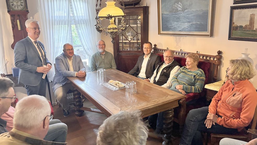 Matthias Groote (stehend) bei der Laudatio für Jürgen Müller (rechts in der Mitte auf der Bank sitzend) im Toornhuus. Foto: Florian Ferber