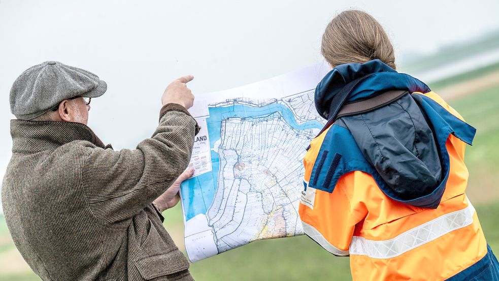 Auf einer historischen Karte des Rheiderlands ist vom Hatzumer Sand noch nichts zu sehen. Wird die Insel in der Ems wieder verschwinden? Friedhelm Roeloffzen (links) vom Wasser- und Schifffahrtsamt und seine Kollegin Nadine Müller glauben nicht daran. Foto: Klaus Ortgies