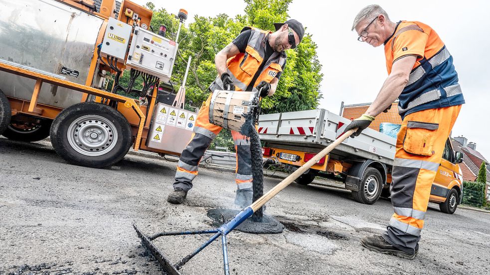 Thomas van Hove (links) und Horst Davids sind beim Bau- und Entsorgungsbetrieb Emden (BEE) ein eingespieltes Team: Sie fahren mit dem neuen Asphaltgusskocher durch die Stadt und reparieren Schlaglöcher und Risse. Fotos: Klaus Ortgies