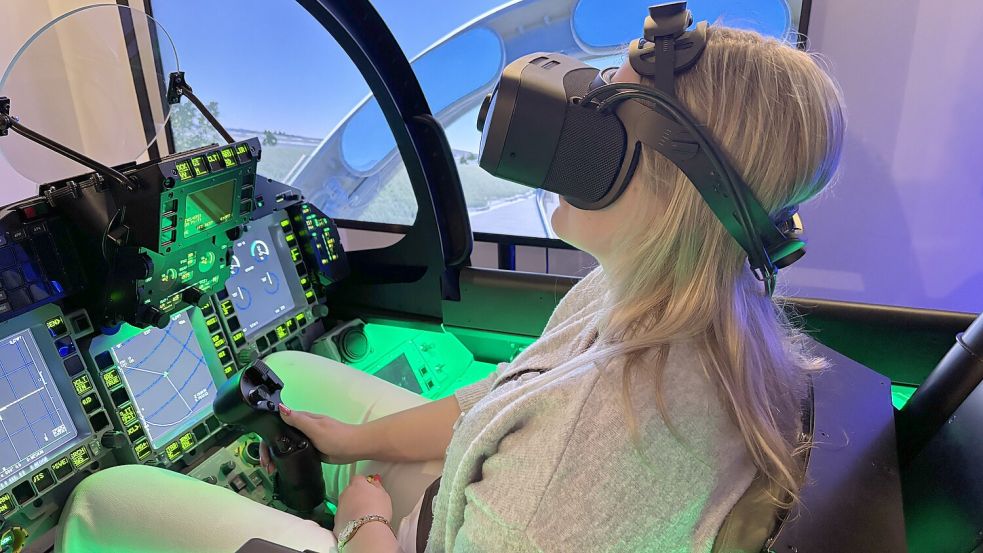 Laura Peters sitzt mit einer VR-Brille auf dem Kopf in einem Eurofighter-Simulator. Fotos: Ute Nobel