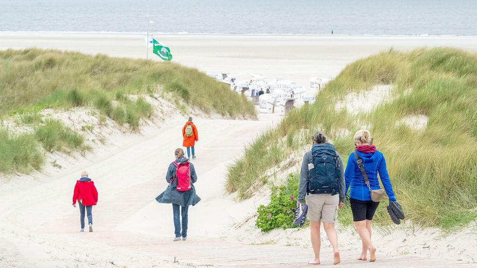 Urlauber auf dem Weg zum Strand der ostfriesischen Insel Spiekeroog. Foto: Sina Schuldt/dpa
