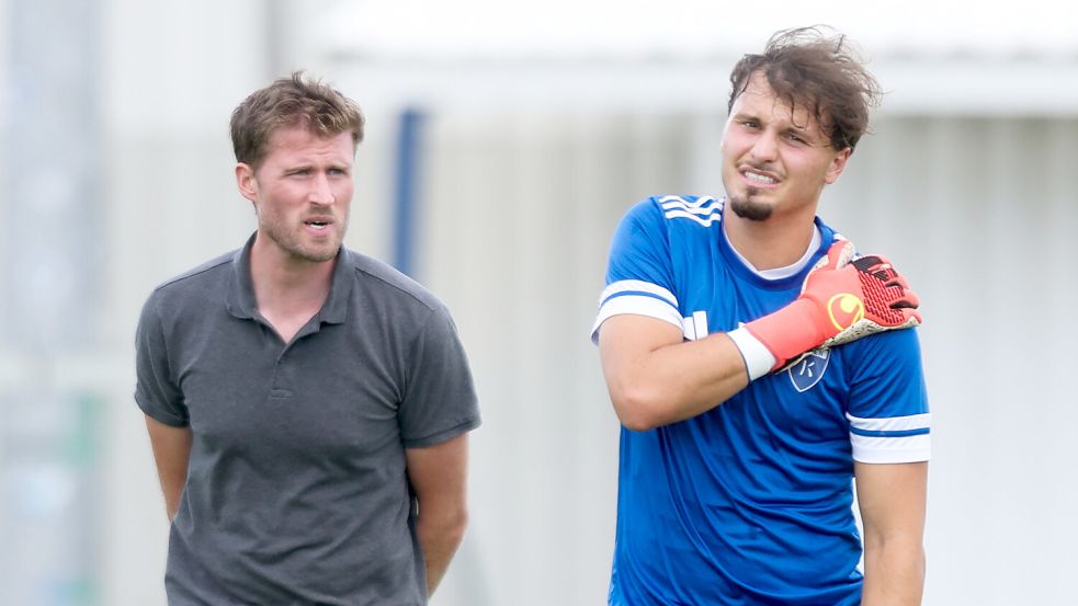 Isaak Djokovic verlässt mit schmerzverzerrtem Gesicht den Trainingsplatz. Neben ihm beobachtet Sebastian Plog (Technischer Direktor) das Geschehen. Foto: Jens Doden/Emden