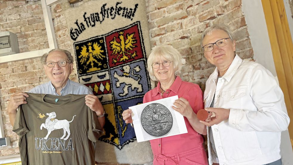 Welche Rolle spielte Focko Ukena für Neermoor? Dieser Frage wollen Jann de Buhr (von links), Ulrike Scharfenberg und Angelika Bekker nachgehen. Sie hoffen auf die Beteiligung weiterer historisch Interessierter. Das Wappentier der Häuptlingsfamilie, ein silberner Löwe, gehört bis heute zum ostfriesischen Wappen (Wandteppich in der Mitte). Foto: Karin Lüppen